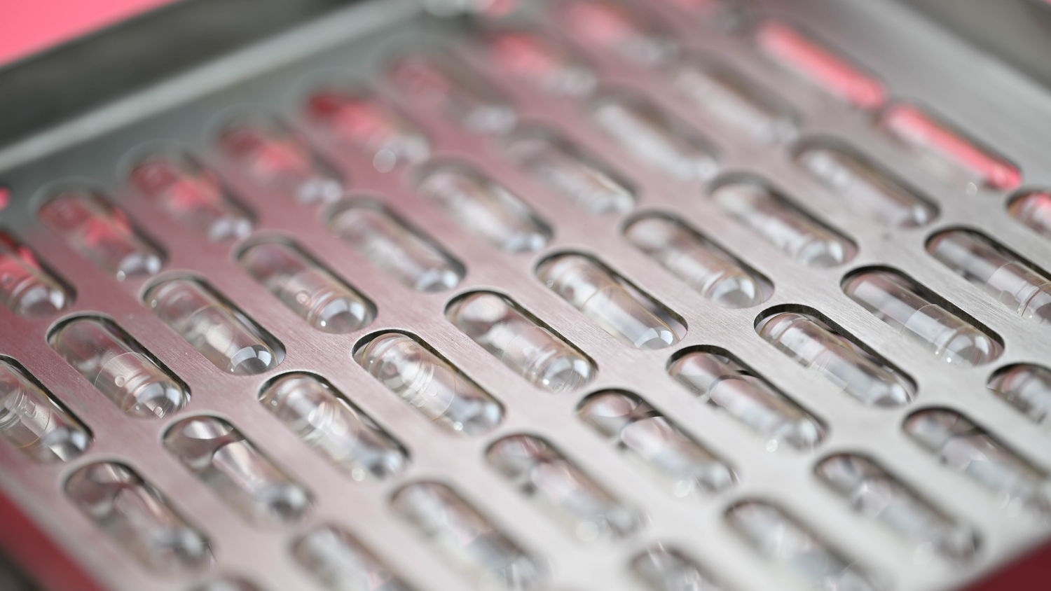 Empty clear gelatin capsules loaded in a capsule filling machine tray ready to be filled with your own clean supplements.