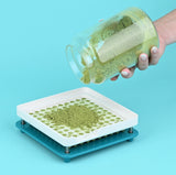 Person pouring green powder from a jar into a capsule filling machine 