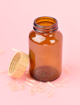amber glass jar with empty capsules scattered around