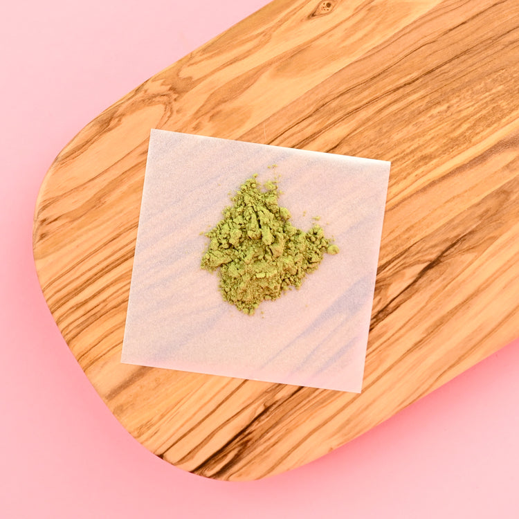 Blate Papes Square sheet with green powder on top which is on a wooden cutting board